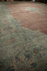 Worn pile texture of a vintage distressed Mahal carpet, featuring copper field and sage floral border.