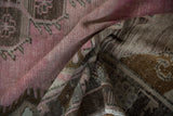 Softly folded vintage Kars runner showing distressed, low-pile texture in blush pink and brown.