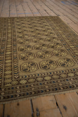 Distressed Afghani rug showing geometric guls with inverted coloration and blue border details.