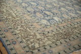 Vintage distressed Sivas carpet corner with intricate antique ivory border and softened denim blue field.