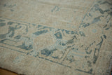Distressed vintage Gorevan carpet corner with faded blue geometric patterns and soft, worn wool pile.