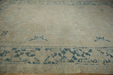 Distressed vintage Gorevan rug showing worn pile with muted ivory and dusty blue tones.