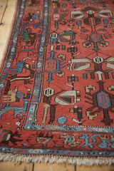 Vintage Persian Borchalou runner: brick red field with stylized motifs and indigo blue border.