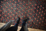 Antique Karabagh rug with repeating madder root rose lattice motif and visible foundation.