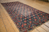 Antique Karabagh rug corner detail, repeating rose motif, and serrated geometric border.