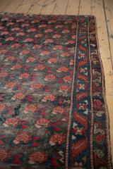 Repeating madder red rose motif with indigo border and worn pile of antique Karabagh rug.