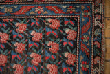 Antique Karabagh rug corner: madder root red rose lattice, indigo blue geometric border.