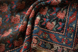 Folded Antique Karabagh rug displaying madder root red roses and indigo geometric border.