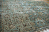 Time-softened aqua field, brown palmettes, and vine border on a vintage Tabriz rug.