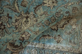 Vintage Tabriz carpet with distressed pile texture and dusty aqua, brown floral motifs.