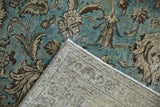 Worn dusty aqua blue floral pile and tightly woven back of a distressed Tabriz carpet.