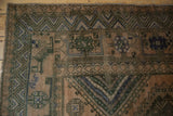 Distressed vintage Shiraz carpet: geometric chevron border with dusty blue and sandalwood.