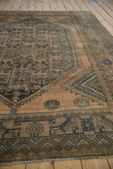Distressed vintage Shiraz rug detail showing geometric patterns, striations, muted blue and charcoal.