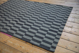 Hand woven geometric pattern on a Pakistani Kilim with alternating silver and charcoal rectangles.