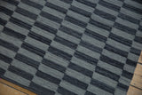 Close-up of the Pakistani Kilim rug, showing alternating charcoal and silver geometric flatweave with abrashes.