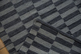 Geometric charcoal and silver flatweave on a Pakistani Kilim rug, showing side cord detail.