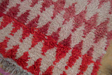 Hand-knotted wool pile of a Moroccan rug with textural abrashes in raspberry and ivory.