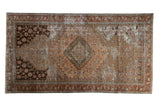 Vintage distressed Malayer rug with central diamond medallion, faded sandalwood, rust, and blue patterns.