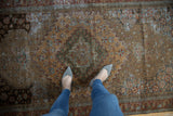 Distressed Malayer rug's decorative low pile texture, showcasing muted earth tones and subtle patterns.
