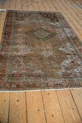 Sandalwood, madder rust, and oxidized silver tones on the distressed Malayer rug pile.