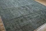 Distressed corner of the Sparta carpet, revealing wear to foundation, intact selvage, and charcoal tones.