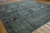 Distressed Sparta carpet pile, highlighting worn charcoal, oxidized silver, and faded floral vinery.