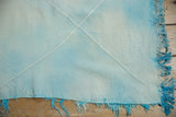 Vintage Turkish Kilim corner with powder blue weave, ivory lattice pattern, and turquoise fringe.