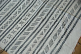 Striated charcoal and ivory lines with repeating geometric shapes on this Moroccan Kilim.
