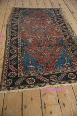Heriz rug corner detail: serrated leaf border and geometric vinery in madder red and blue.