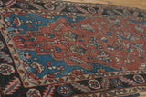 Vintage Heriz runner with madder red field, sapphire geometric vinery, and serrated border.