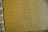 Hand woven Moroccan rag rug texture, saffron yellow to pale gold abrash, braided fringe.