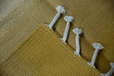 Hand woven Moroccan Rag Rug showing saffron yellow abrash texture and braided fringe.