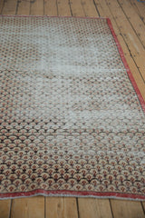Vintage Sparta rug pattern detail: ivory, red, charcoal scalloped lattice with visible pile wear.