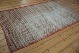 Vintage Sparta rug's scalloped lattice pattern, ivory, cherry, charcoal, with evident wear.