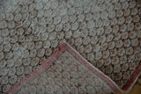 Corner of vintage Turkish Sparta rug, ivory red scalloped pattern, exposed foundation, red selvage.