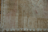 Detail of distressed Kars carpet with abrashed field, even pile wear, and chevron border.