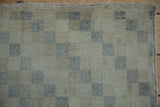 Close-up of distressed ivory and slate checkered pattern with visible wear.