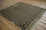 Distressed Oushak rug corner: chocolate brown and oxidized silver geometric motifs.