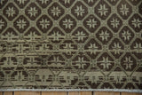 Oushak rug close-up: distressed chocolate charcoal and oxidized silver geometric pattern with fringe.
