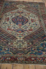 Low perspective view of a vintage Baktiari rug's central indigo medallion and low-pile texture.