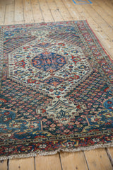Angled view of a Persian Baktiari rug's central indigo medallion and colorful floral field.