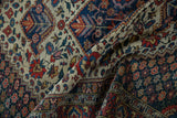 Close view of a vintage Baktiari rug's low pile texture and intricate floral vinery pattern.