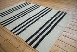 Horizontal charcoal stripes and silvery flatweave texture on a Pakistani Kilim rug.
