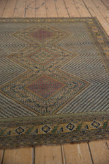 Intricate zigzag main field and serrated outlines in camel, navy, and red on this antique Afshar.