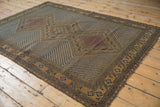 Antique Afshar rug with red lattice medallion, zigzag field, and tattered camel border.