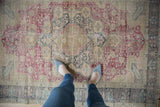 A personal perspective looking down at the vintage Kaisary rug's time-softened, worn texture.