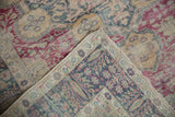 Folded corner of the vintage Turkish rug showing its hand-knotted foundation and worn pile.