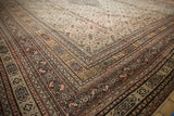 Angled view of the intricate, multi-layered borders on an antique hand-knotted Doroksh carpet.