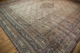 Angled perspective on an antique Doroksh carpet showing its complex borders and ivory Herati field.
