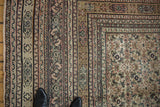 Intricate borders of an antique Doroksh carpet showing blush, black, and bronze Herati patterns.